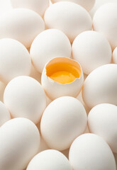 White eggs on a white background, one egg is broken, unlike the others.