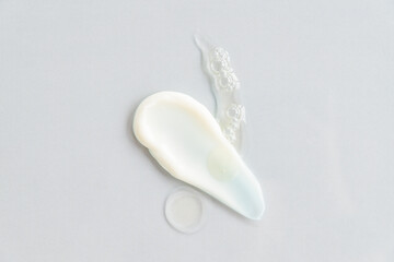 top view of cosmetic cream smear and beauty oil drops on gray background. beauty treatment products...