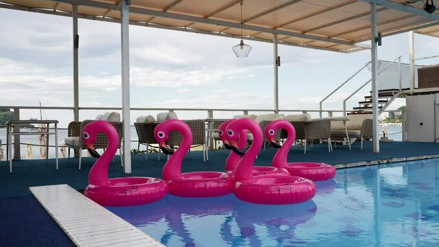 beach flamingos. Pink pool inflatable flamingos for summer beach, in a beautiful indoor pool. Flamingos swim in the corner of the pool.