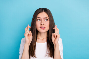 Portrait of attractive terrified anxious lady with crossed fingers worrying about exam isolated on blue color background