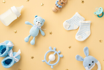 Baby accessories concept. Top view photo of blue knitted booties teddy-bear toy milk bottle socks...