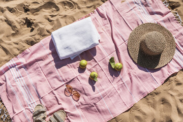 Summer beach accessories flat lay on sand background. Holiday travel, tropical concept. Straw hat,...