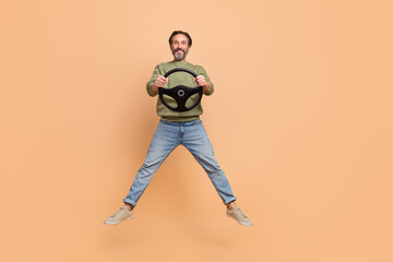 Fototapeta na wymiar Full size portrait of satisfied excited man hold wheel have good mood isolated on beige color background