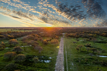 Sunset in the countryside in the province of buenos aires, argentina. aerial image of an empty dirt road.
