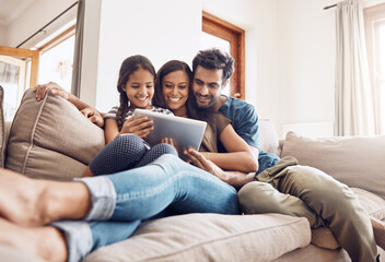 Making screen time bonding time. Shot of a mother and father using a digital tablet with their daughter on the sofa at home. - Powered by Adobe