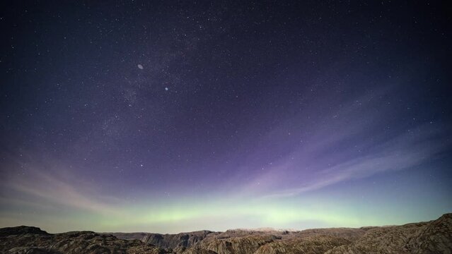 Mesmerizing timelapse of the northern lights in the dark night sky above the mountains. Parallax video.