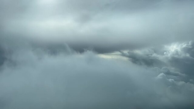 Awesome aerial pilot point of view flying through a turbulent and stormy  sky looking for a gap through the clouds to avoid problems. 4K