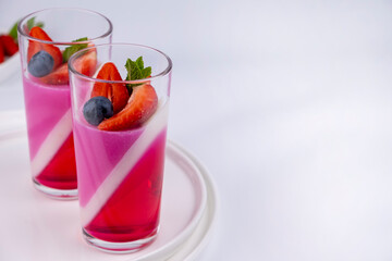 Fruit jelly dessert or panna cotta with fresh strawberries and blueberries, banner, copy space,...