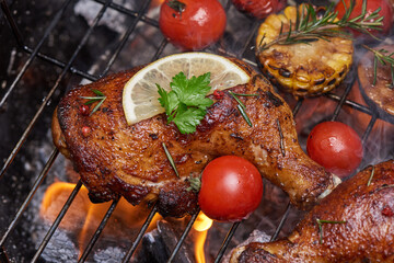 Grilled chicken legs on the flaming grill with grilled vegetables with tomatoes, potatoes, pepper seeds, salt. top view with copy space. tasty snack. flat lay. healthy lunch menu. diet food.