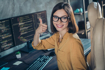 Portrait of beautiful cheerful girl web designer developing web startup showing thumbup done at...