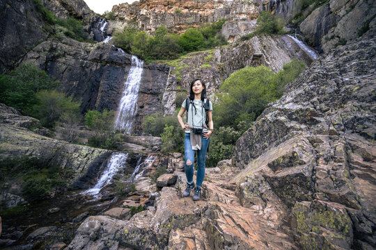 Asian hiker near waterfall in mountains