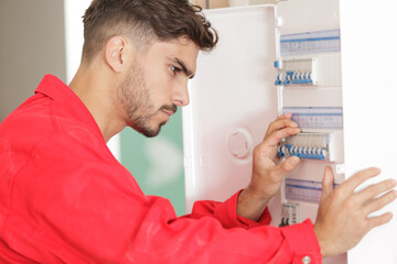 male electrician working on circuit breaker cabinet