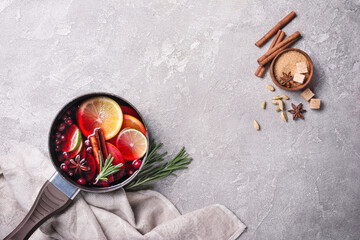 Mulled wine with slices of citrus fruits, berries and aromatic spices