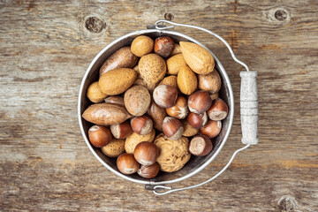 Old tin bucket with assortment of nuts in shells
