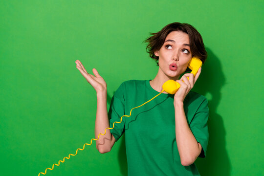 Photo of pretty dreamy lady wear spring outfit looking empty space talking phone isolated green color background