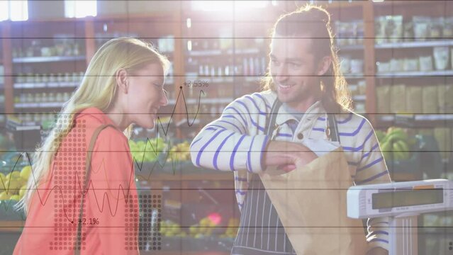 Animation of financial graphs over happy caucasian male seller and female customer in grocery shop - Powered by Adobe