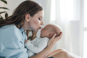 happy mother with little cute newborn at home