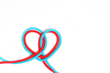 Heart symbol made of two braided cords on gray