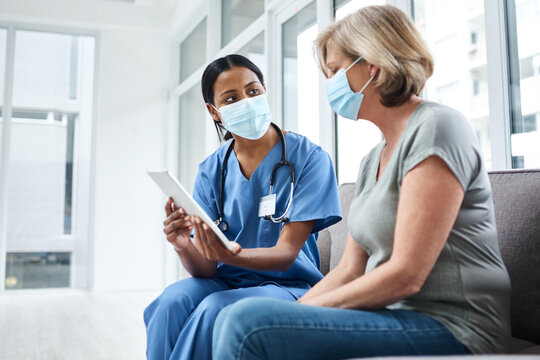 Personal Treatment Plans Tailored To Every Patient. Shot Of A Young Doctor Using A Digital Tablet During A Consultation With A Senior Woman.