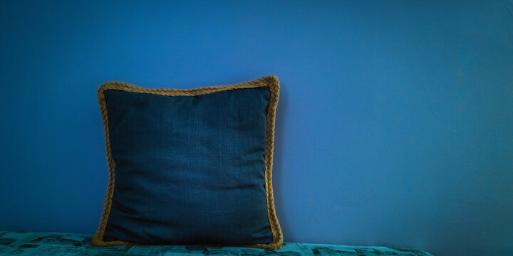 Blue throw pillow in front of the blue wall in the room