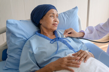 Cancer patient woman wearing head scarf after chemotherapy consulting and visiting doctor in hospital....