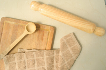 Wood rolling  pin, wood spoon, wood table, kitchen towel on a kitchen top 
