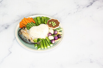 Rice with fried mackerel, shrimp paste, chilli sauce and vegetables, original Thai food.On wooden table.