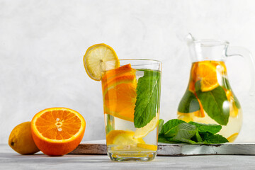 Citrus drink with lemon, orange and mint. Healthy and healthy drink in a transparent glass with copy space