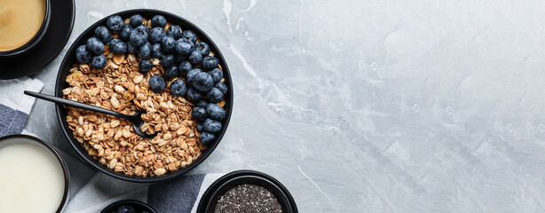 Bowl of oat with blueberries served on light marble table, flat lay with space for text. Banner...