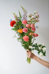 hand holding bouquet of ranunculus 