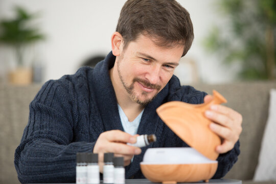 Man Dripping Essential Oil Into A Diffuser