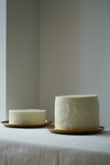 Two clean white icing cake without decorating in light interior on golden plate