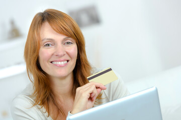 woman smiling holding a credit card