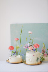 Beautiful fresh different sized cakes decorated with flowers on a blue background