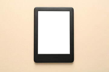 Modern e-book reader with blank screen on beige background, top view