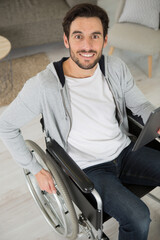 Fototapeta na wymiar man in a wheelchair holding a tablet pc