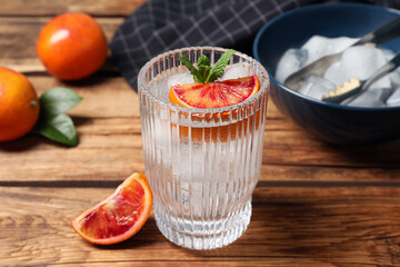 Delicious refreshing drink with sicilian orange and mint on wooden table