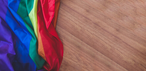Rainbow flag on brown wooden table, Lgbt, Lgbtq, Lgbtq+