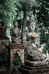 Fototapeta na wymiar Estatuas de piedra de templo budista perdido en la montaña. Wat Phra Lat, en ciudad de Chiang Mai, Tailandia
