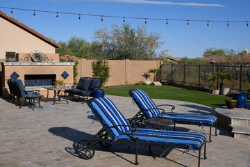 A desert landscaped yard in Arizona featuring a travertine tile pool deck.