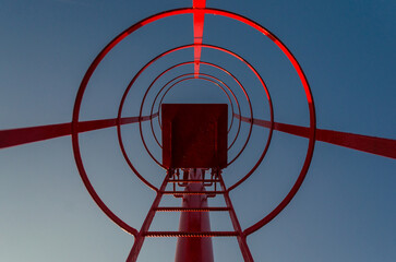 La scala rossa di un piccolo faro in un porto 