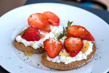 Healthy toast with strawberry, cottage cheese and honey. Tasty breakfast. Summer appetizer.