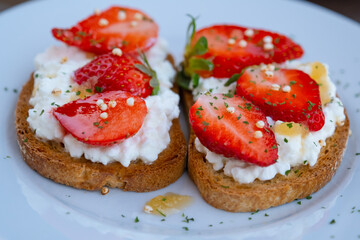Healthy toast with strawberry, cottage cheese and honey. Tasty breakfast. Summer appetizer