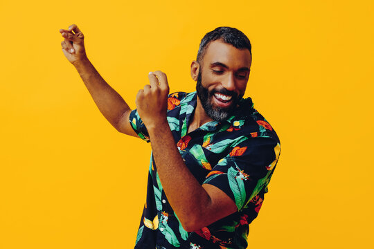 close up handsome bearded mid adult african american man smiling and dancing wearing Hawaiian shirt on vacation studio shot
