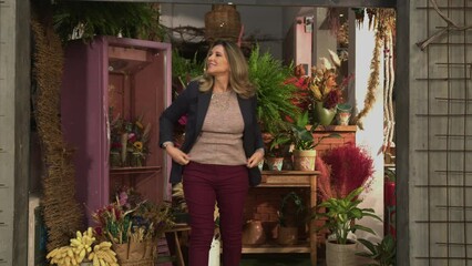 Local small business female owner opening shop door. Woman entrepreneur standing at flower store at street level