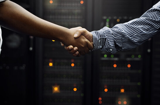 Paired up for professional IT service. Cropped shot of two unrecognizable men shaking hands in front of a server in a data center.
