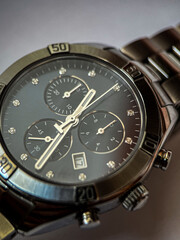 Luxury stainless steel watch with chronograph, dark blue dial and metal bracelet close-up. Macrophotography of watch details