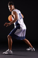 Defend defend defend. Studio shot of a basketball player against a black background.