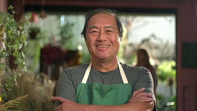 Portrait of one Asian employee standing at flower shop smiling wearing apron. Small business entrepreneurship