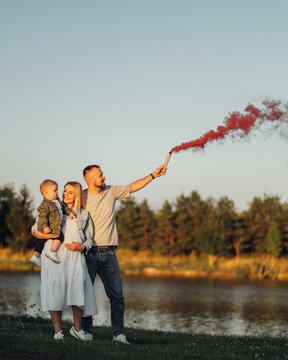 It's A Girl, Young Family, Mother And Father With Toddler Son Taking Baby Gender Reveal Of Their Next Child By Smoke Bomb